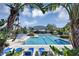 Community pool and pool deck offer lounge chairs, beautiful landscaping, and great sun exposure at 3398 Greenwich Village Blvd # 104, Orlando, FL 32835