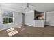 Bright living room featuring wood floors, a ceiling fan, a large window, and an open view of the adjacent kitchen at 3398 Greenwich Village Blvd # 104, Orlando, FL 32835