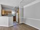 Open living space featuring wood floors, white trim, and a partial view of the kitchen and stainless appliances at 3398 Greenwich Village Blvd # 104, Orlando, FL 32835