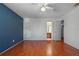 Spacious main bedroom featuring wood floors, a ceiling fan, and ensuite bathroom and closet access at 3605 S Saint Lucie Dr, Casselberry, FL 32707