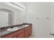 Bathroom with dual sinks, granite counters, and large mirror, brightened by modern lighting at 3747 Moon Dancer Pl, St Cloud, FL 34772