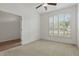 Well-lit bedroom featuring neutral carpet, ceiling fan, and a large window with shutter blinds at 3747 Moon Dancer Pl, St Cloud, FL 34772