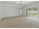 Open-concept living room featuring neutral carpet, a sliding door, and a modern light fixture at 3747 Moon Dancer Pl, St Cloud, FL 34772