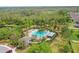 Aerial view of community pool with tropical landscaping, nearby pond, and neighborhood amenities at 3747 Moon Dancer Pl, St Cloud, FL 34772