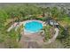 Aerial view of a sparkling community pool surrounded by lush landscaping and ample seating at 3747 Moon Dancer Pl, St Cloud, FL 34772