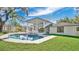 A backyard pool and spa is adjacent to a modern two-story home featuring large glass walls at 409 W 2Nd Ave, Windermere, FL 34786