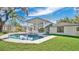 This backyard features a sparkling pool and spa, surrounded by lush greenery and a patio area at 409 W 2Nd Ave, Windermere, FL 34786