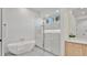 Modern bathroom with white marble walk-in shower, soaking tub and wooden cabinet at 409 W 2Nd Ave, Windermere, FL 34786