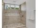 Modern bathroom shower with gray and white tile, a glass door, and a built-in shelf at 409 W 2Nd Ave, Windermere, FL 34786