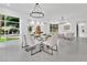 Bright dining room with modern table, chairs, chandelier and large windows showing the outdoor landscape at 409 W 2Nd Ave, Windermere, FL 34786