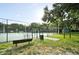 Fenced tennis court with benches and information signage, providing a dedicated space for tennis enthusiasts at 409 W 2Nd Ave, Windermere, FL 34786