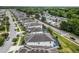 Serene aerial neighborhood view showcases gray-roofed homes, lush greenery, and a community featuring a nearby RV park and adjacent roads at 418 Marcello Blvd, Kissimmee, FL 34746