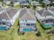 Aerial view of a home with a screened-in pool and lush green lawn in a residential neighborhood at 418 Marcello Blvd, Kissimmee, FL 34746