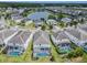 Scenic aerial shot of a neighborhood near a tranquil lake, showcasing well-maintained two-story homes with screened-in pools and landscaping at 418 Marcello Blvd, Kissimmee, FL 34746