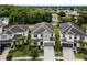 Stunning aerial view of a well-manicured two-story home showcasing a gray roof, complemented by lush landscaping and a spacious driveway at 418 Marcello Blvd, Kissimmee, FL 34746