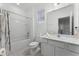 Bright, all-white bathroom with tub/shower, featuring modern fixtures, tile floor and ample lighting at 418 Marcello Blvd, Kissimmee, FL 34746