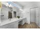 Elegant bathroom with double sinks, wood tile floors, and a separate glass-enclosed shower for a spa-like experience at 418 Marcello Blvd, Kissimmee, FL 34746