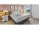 Inviting bedroom features a queen bed, decorative prints, wood headboard and bedside table with lamp at 418 Marcello Blvd, Kissimmee, FL 34746