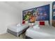 Comfortable bedroom featuring two beds, a small table, and a comic book themed wall art at 418 Marcello Blvd, Kissimmee, FL 34746