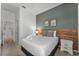 Stylish bedroom showcasing a queen bed with a gray accent wall, wood headboard, and neutral decor at 418 Marcello Blvd, Kissimmee, FL 34746