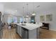 Open-concept kitchen with a large island, modern pendant lights, and stainless steel appliances at 418 Marcello Blvd, Kissimmee, FL 34746