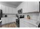 Clean kitchen featuring stainless steel appliances, white cabinets and quartz countertops at 418 Marcello Blvd, Kissimmee, FL 34746