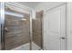 Contemporary shower with glass enclosure, featuring modern fixtures and stylish wood-look tile at 418 Marcello Blvd, Kissimmee, FL 34746