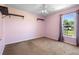 Bright bedroom featuring neutral carpet, soft pink walls, ceiling fan, and outdoor views at 421 Blackbird Way, Kissimmee, FL 34759