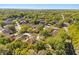 Expansive aerial view showcasing a neighborhood with numerous houses nestled among mature trees and green spaces under a clear sky at 4424 Park Eden Cir, Orlando, FL 32810