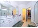 Bright bathroom with double vanity, tile floor, glass shower, and adjacent walk-in closet at 4561 Cabello Loop, Kissimmee, FL 34746
