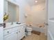 A well-lit bathroom features a white vanity with a large mirror, tiled floors, and shower-tub combo at 4561 Cabello Loop, Kissimmee, FL 34746