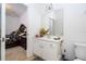 Bathroom with a white vanity, a large mirror, and an open doorway to a bedroom at 4561 Cabello Loop, Kissimmee, FL 34746