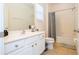 Bright bathroom showcasing a white vanity, toilet, and a shower/tub combination with gray curtain at 4561 Cabello Loop, Kissimmee, FL 34746