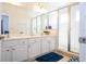Bright bathroom featuring double sinks with white vanity, shower with glass door and tile floors at 4561 Cabello Loop, Kissimmee, FL 34746