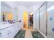 Bright primary bathroom featuring double vanities, a walk-in closet, and a glass-enclosed shower at 4561 Cabello Loop, Kissimmee, FL 34746