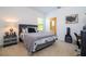 Comfortable bedroom featuring neutral tones, a cozy bed, and a gray upholstered headboard and nightstand at 4561 Cabello Loop, Kissimmee, FL 34746