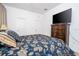 Cozy bedroom featuring a plush bed, chest of drawers with TV, and neutral color palette at 4561 Cabello Loop, Kissimmee, FL 34746