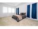 Spacious carpeted bedroom featuring tray ceilings, large windows and decorative blue curtains at 4561 Cabello Loop, Kissimmee, FL 34746