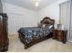 Comfortable bedroom with a decorative wooden bed frame, patterned bedding, side tables, and a spacious closet at 4561 Cabello Loop, Kissimmee, FL 34746
