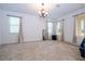 Spacious bedroom with three windows, neutral carpet, chandelier and curtains at 4561 Cabello Loop, Kissimmee, FL 34746