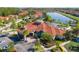 A beautiful aerial view of the community clubhouse, pool, and surrounding residences, set against a backdrop of a serene lake at 4561 Cabello Loop, Kissimmee, FL 34746