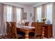 Dining area showcases a wooden table, chairs, and curtains, creating a welcoming atmosphere at 4561 Cabello Loop, Kissimmee, FL 34746