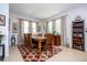 Formal dining room featuring a wooden table, matching chairs, and elegant window treatments at 4561 Cabello Loop, Kissimmee, FL 34746