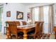 Elegant dining area with a wooden table set for six, complemented by stylish artwork at 4561 Cabello Loop, Kissimmee, FL 34746