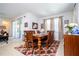 Open dining room with a wood table, seating for six, and natural light from the sliding doors at 4561 Cabello Loop, Kissimmee, FL 34746