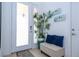 Inviting entryway featuring a bench with blue pillows, plant, and frosted glass door with sidelight at 4561 Cabello Loop, Kissimmee, FL 34746