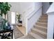 Inviting foyer with neutral tones, staircase, decorative rug, and bright natural light from the front door at 4561 Cabello Loop, Kissimmee, FL 34746