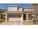 Inviting front exterior of a two-story home with a two-car garage, well-maintained lawn, and lovely landscaping at 4561 Cabello Loop, Kissimmee, FL 34746