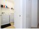 Laundry room featuring a white washer and dryer with storage shelves at 4561 Cabello Loop, Kissimmee, FL 34746