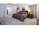 Bright main bedroom featuring a large bed, decorative rug, and ensuite bathroom with a glass-enclosed shower at 4561 Cabello Loop, Kissimmee, FL 34746